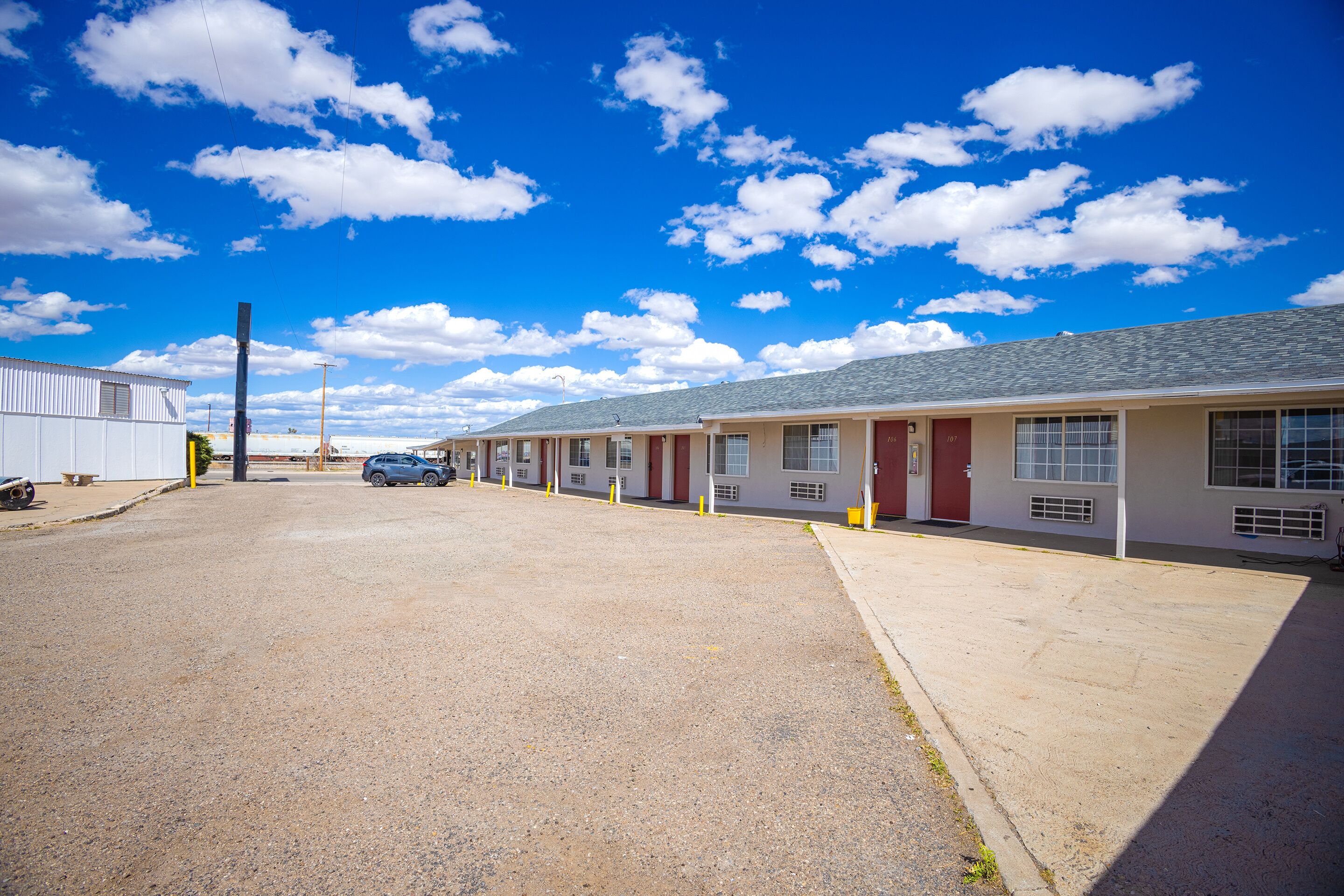 A row of motel rooms with a clear sky and a few clouds.