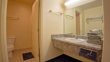 A bathroom with a sink, mirror, towel rack, and toilet.