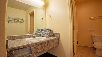 A bathroom with a sink, mirror, towel rack, and toilet.