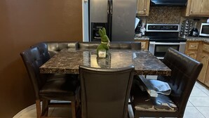 Un espace repas avec une table en marbre et des chaises en cuir.