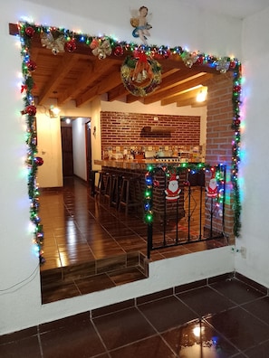 A kitchen with a brick wall, wooden ceiling, and a tiled floor.