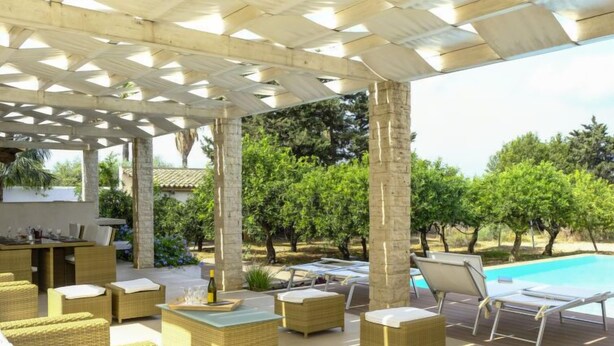 An outdoor patio area with wicker furniture, a pool, and a pergola structure. - Barbara by Interhome (Marsala)