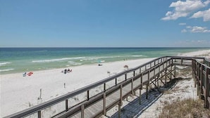 A beach with a wooden boardwalk leading to the shore.