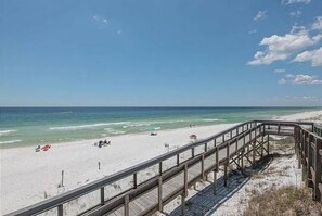 A beach with a wooden boardwalk leading to the shore.