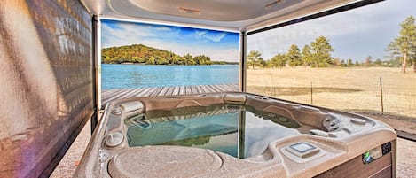 Un bain à remous avec vue sur un lac et une terrasse en bois.