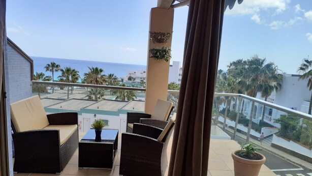 A balcony with wicker furniture, a small table with a plant, and a potted plant. - ESQUINZO POOL AND BEACH (Esquinzo)