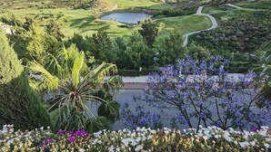 Ein Golfplatz mit einem See, umgeben von viel Grün und Blumen.