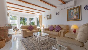 Uma sala de estar com lareira, dois sofás, uma mesa de centro e um tapete.
