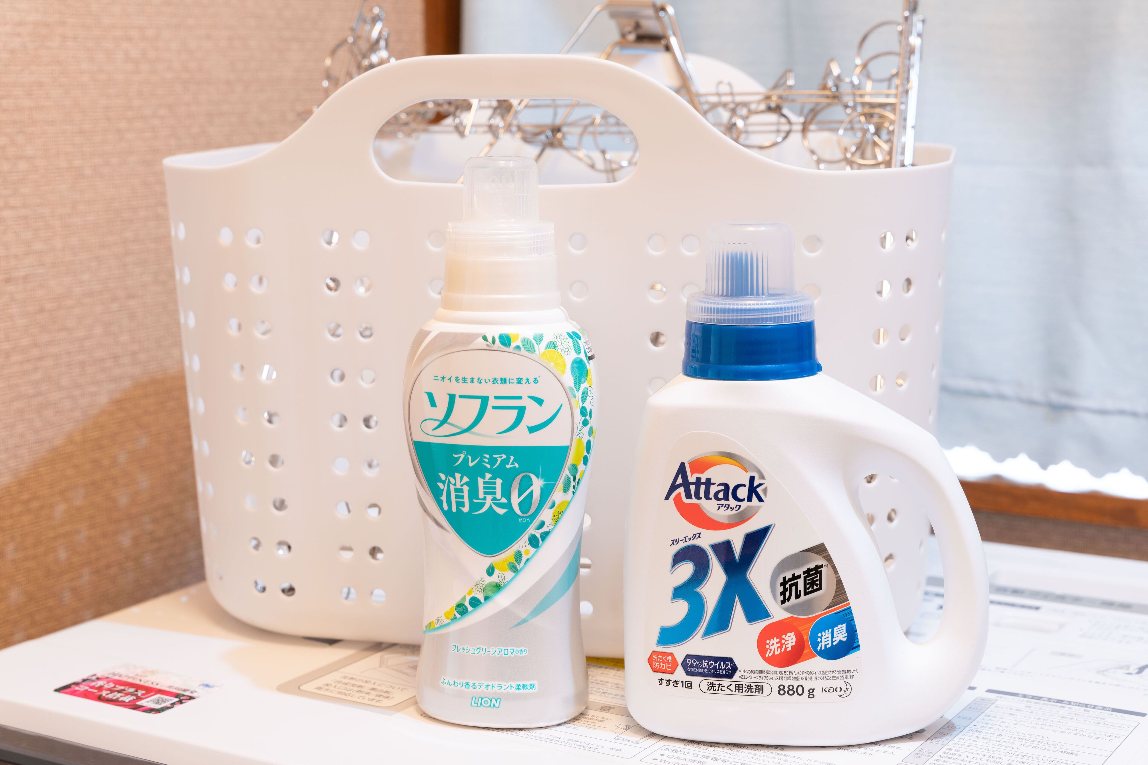 A white plastic basket containing two bottles of laundry detergent.