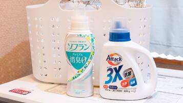 A white plastic basket containing two bottles of laundry detergent.