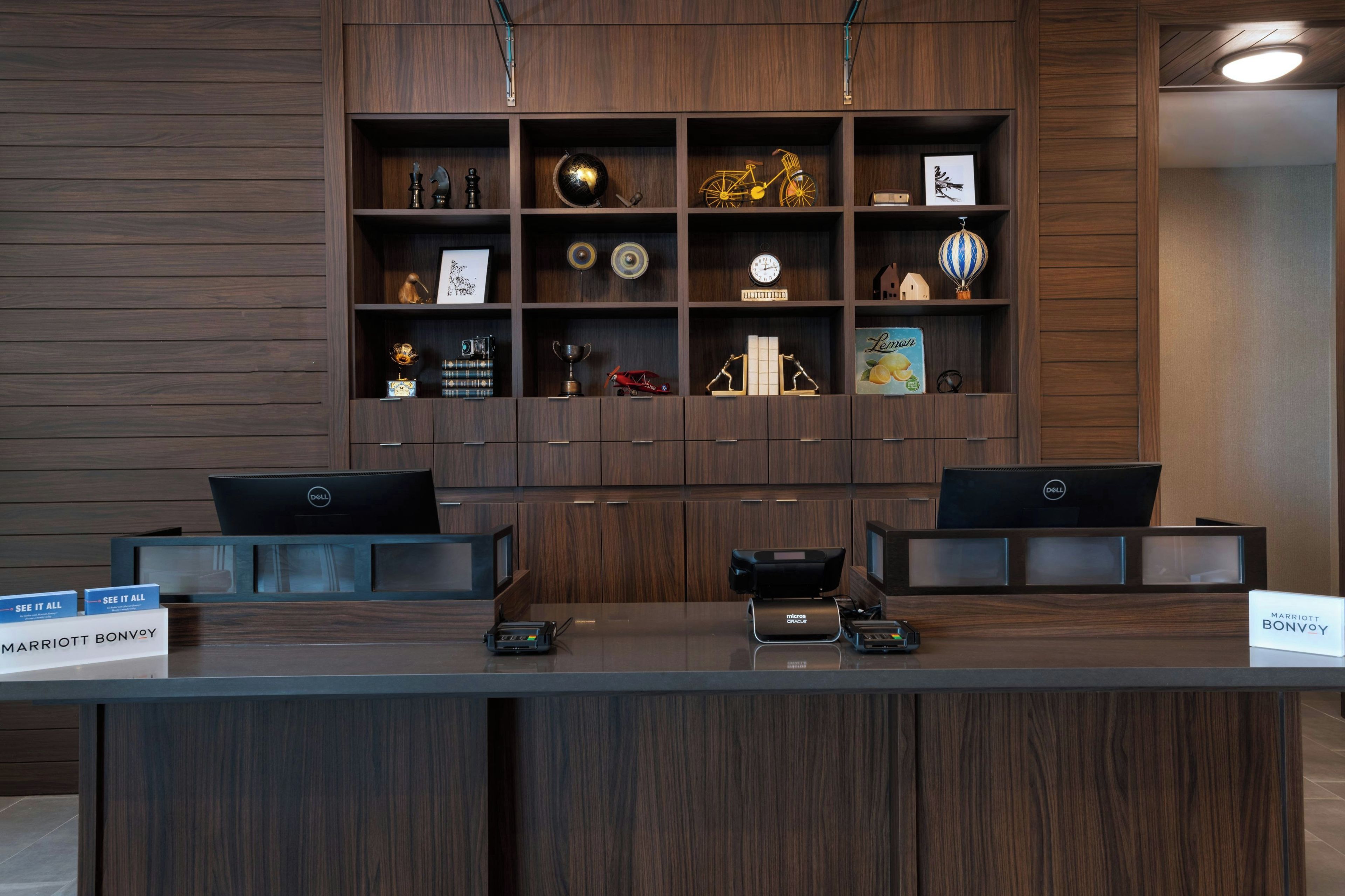 A reception desk with two Dell computers, a microfiche reader, and a sign for Marriott Bonvoy.