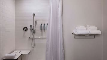 Un baño moderno con ducha, toallero y artículos de aseo.