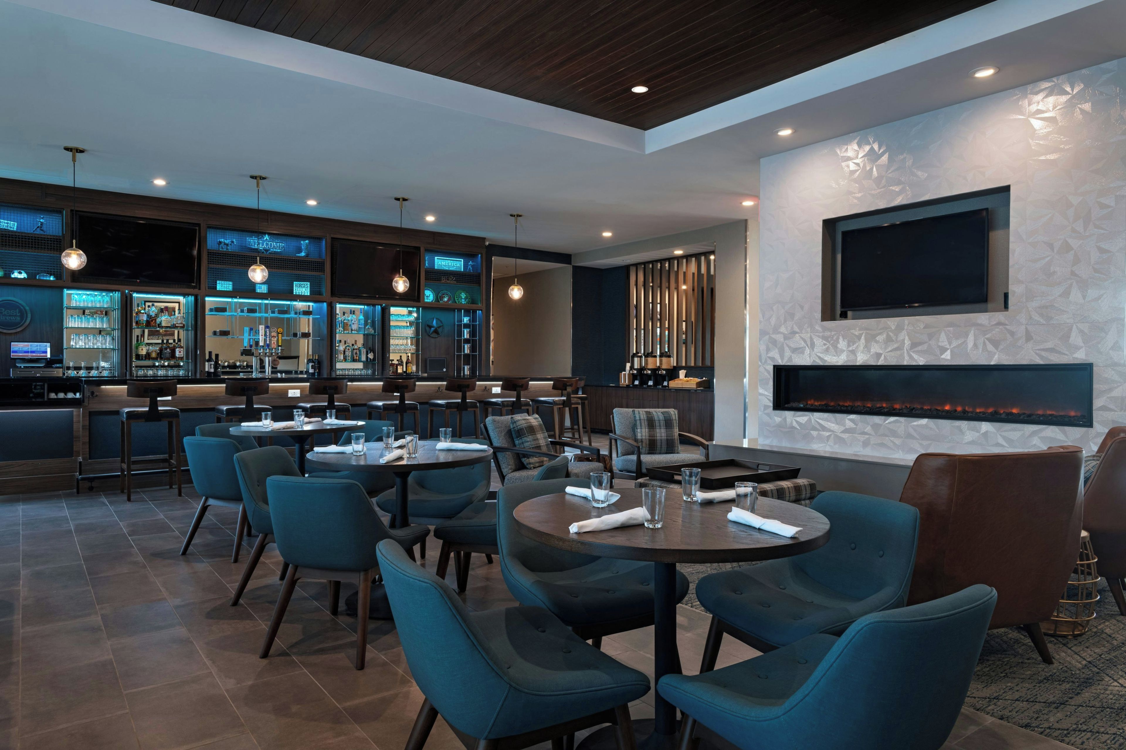 A modern bar area with seating and a fireplace.