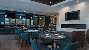 A modern bar area with seating and a fireplace.