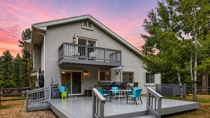 A two-story house with a balcony, outdoor seating area, and a deck. - Scenic Mountainside Home with Deck and Yard (Larkspur)