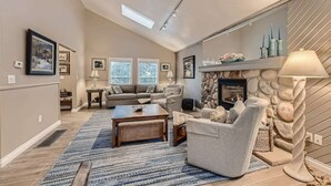 A spacious living room with a fireplace, a sofa set, a coffee table, and a rug. - Scenic Mountainside Home with Deck and Yard (Larkspur)
