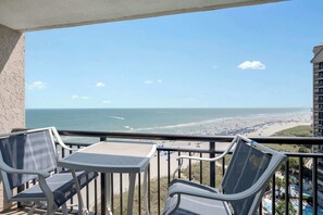 A balcony with a view of a beach and ocean.