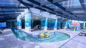 An indoor swimming pool with a clear water feature, a yellow float, and a tiled floor. - Recently Renovated, Oceanfront View, Heated Pools! (Myrtle Beach)