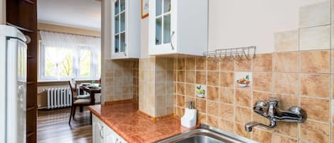 Réfrigérateur, un four, surface de cuisson, vaisselle et ustensiles