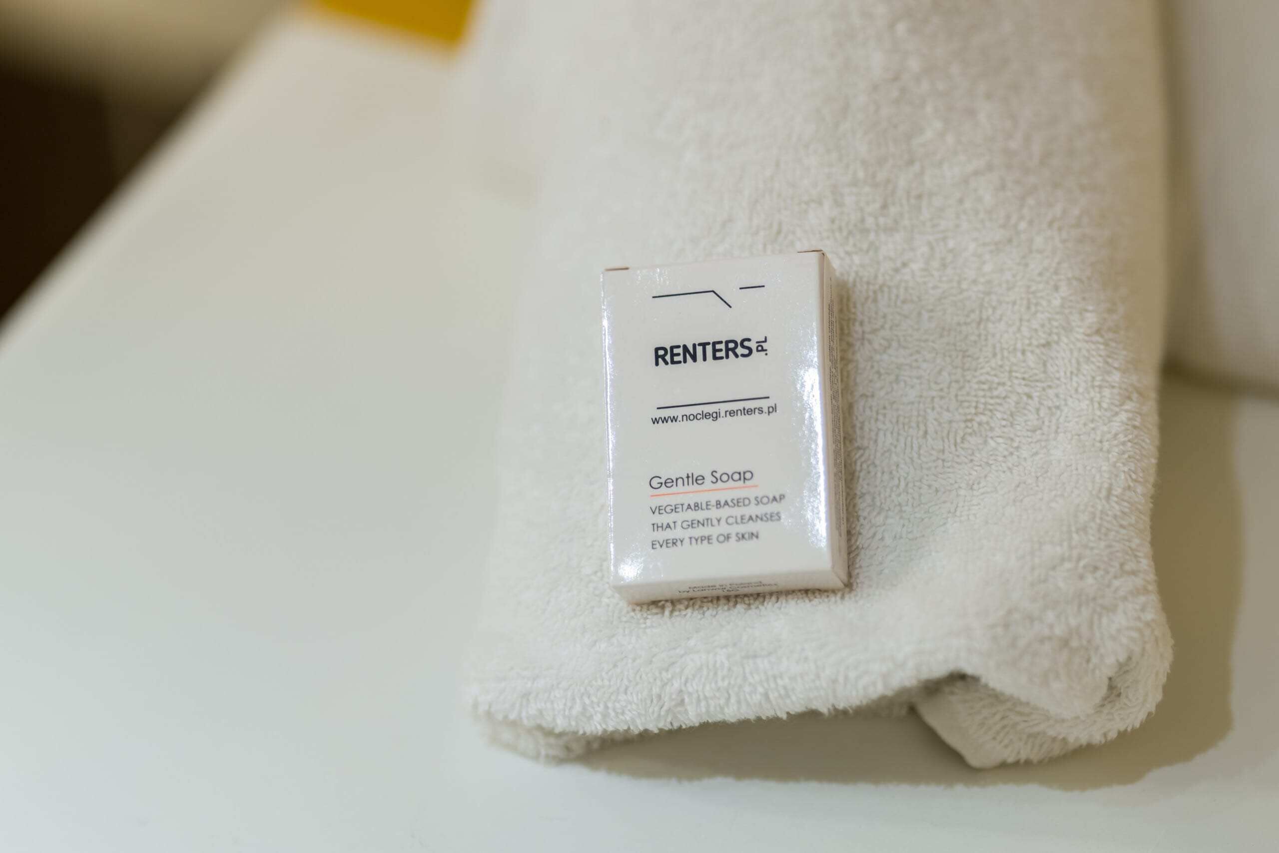 A white box labeled "RENTERS" with a website URL and "Gentle Soap" text on a white towel.