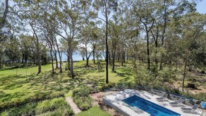 Un espace piscine offrant une vue dégagée sur le paysage environnant, notamment sur les arbres et une étendue d’eau.