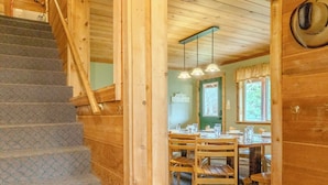 A wooden interior with a staircase leading to a dining area. - Alpine Star Lodge (West Yellowstone)