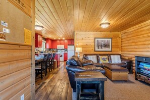 Ein rustikales Blockhaus mit Essbereich, Wohnzimmer mit Ledersofa und Küche.
