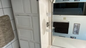 Un baño con un lavabo blanco, un perchero para toallas y un espejo.
