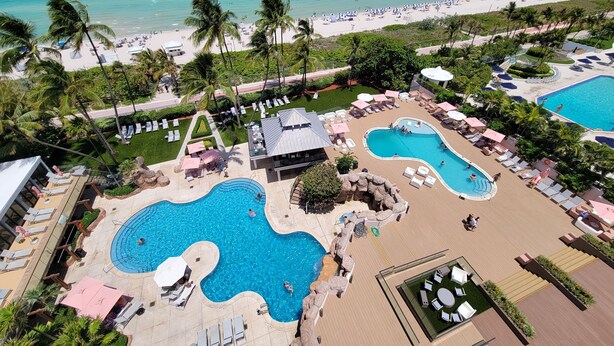 A resort with multiple swimming pools, sun loungers, and a beach area. - Modern 3 Bedroom with Ocean Views - 1104 (Miami Beach)
