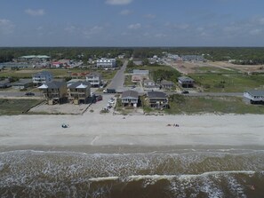 A coastal town with beachfront properties, a main road, and a beach.