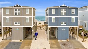 Una propiedad frente a la playa con edificios de dos pisos, cada uno con un porche cubierto y un pequeño área de terraza.