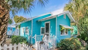 A turquoise house with a white picket fence, a porch, and a sign that reads "Old Love." - Romantic 1930s Vintage Beach Cottage Steps to Beach by Tybee Cottages (Tybee Isand)