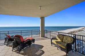 Relax in style with ocean views from this covered outdoor space, featuring two comfortable chairs and a tiled floor.