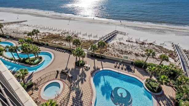 Ein Resort mit mehreren Schwimmbecken, einem Strand und freiem Blick auf den Ozean.