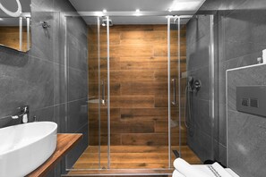Suite estudio Deluxe, cocina, vistas a la ciudad | Baño | Ducha, cabezal de ducha tipo lluvia, secador de pelo y toallas