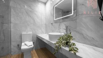 Deluxe Suite, Kitchen | Bathroom | Shower, rainfall showerhead, hair dryer, towels