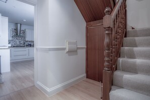 A staircase with wooden balusters and a carpeted landing. - South Beach View- 2 Bedroom - Tenby (Tenby)