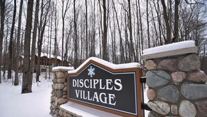 Eine Steinmauer mit einem Schild, auf dem 'Disciples Village' steht.