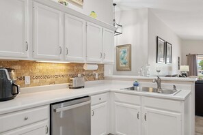 A kitchen with white cabinets, a toaster, a coffee maker, a dishwasher, and a sink. - Painted Mountain Golf Retreat /On Golf Course/Private Heated Pool (Mesa)