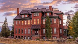 A large, multi-story brick building with a symmetrical facade, multiple windows, and a prominent central entrance. - Chic 2BR: Near Downtown, Copper Mountain (Leadville)