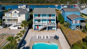 A beachfront property with a swimming pool, multiple balconies, and a view of the ocean. - Spacious 5 BR House with Private Pool and ICW views (Holden Beach)