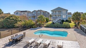 A residential area with a swimming pool, outdoor seating, and multiple houses. - Spacious 5 BR House with Private Pool and ICW views (Holden Beach)