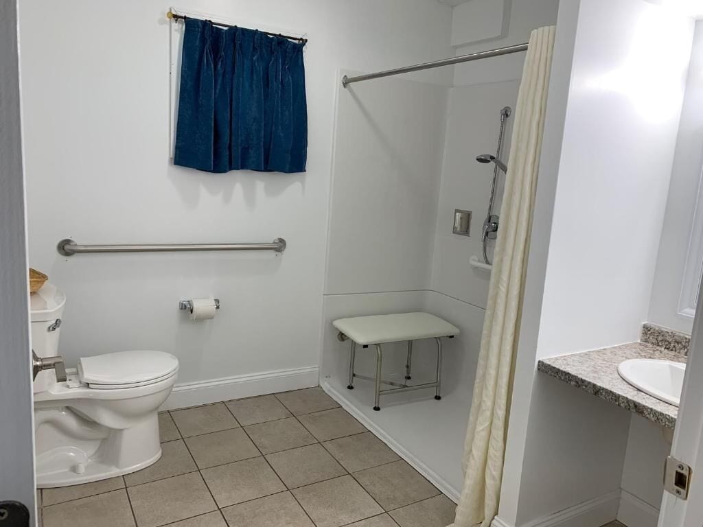 Een badkamer met toilet, douche en wastafel.
