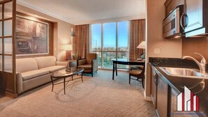 Une chambre d’hôtel moderne équipée d’un canapé, d’une table basse, d’une table à manger et d’un coin cuisine.