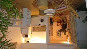 A kitchen with a microwave, a washing machine, and a hanging wicker chair. - beautiful studio in st martin (Saint Martin)