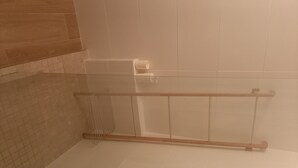 A bathroom with a glass shower enclosure, a wooden floor, and tiled walls. - beautiful studio in st martin (Saint Martin)