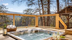 A hot tub on a wooden deck with a view of trees and mountains. - Lakeshore Retreat with Lake Lanier views & hot tub (Landrum)