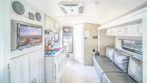 Cocina compacta para camper con estufa, microondas y refrigerador integrados.