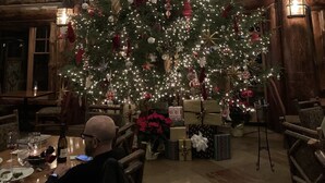 A large Christmas tree decorated with lights and ornaments in a rustic wooden room with a high ceiling and large windows. - 20-50% OFF RESORT RACK RATES!  Experience Breathtaking Autumn Foliage in Luxury (Lake Placid)
