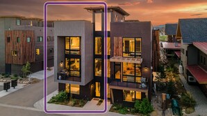 Un edificio moderno de dos pisos con ventanas amplias y un balcón.